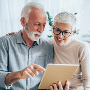 Man and a woman looking at a tablet together.