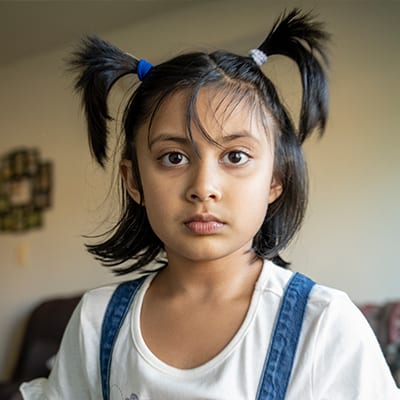 Mixed race young child with her hair in two short pig tails.