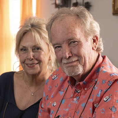 Happy elderly couple looking at you with smiles.